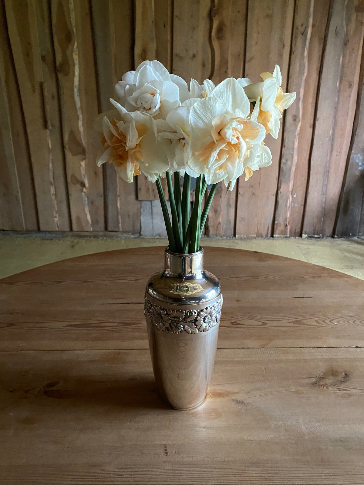 Silvervas med krans av blomstermönster runt om