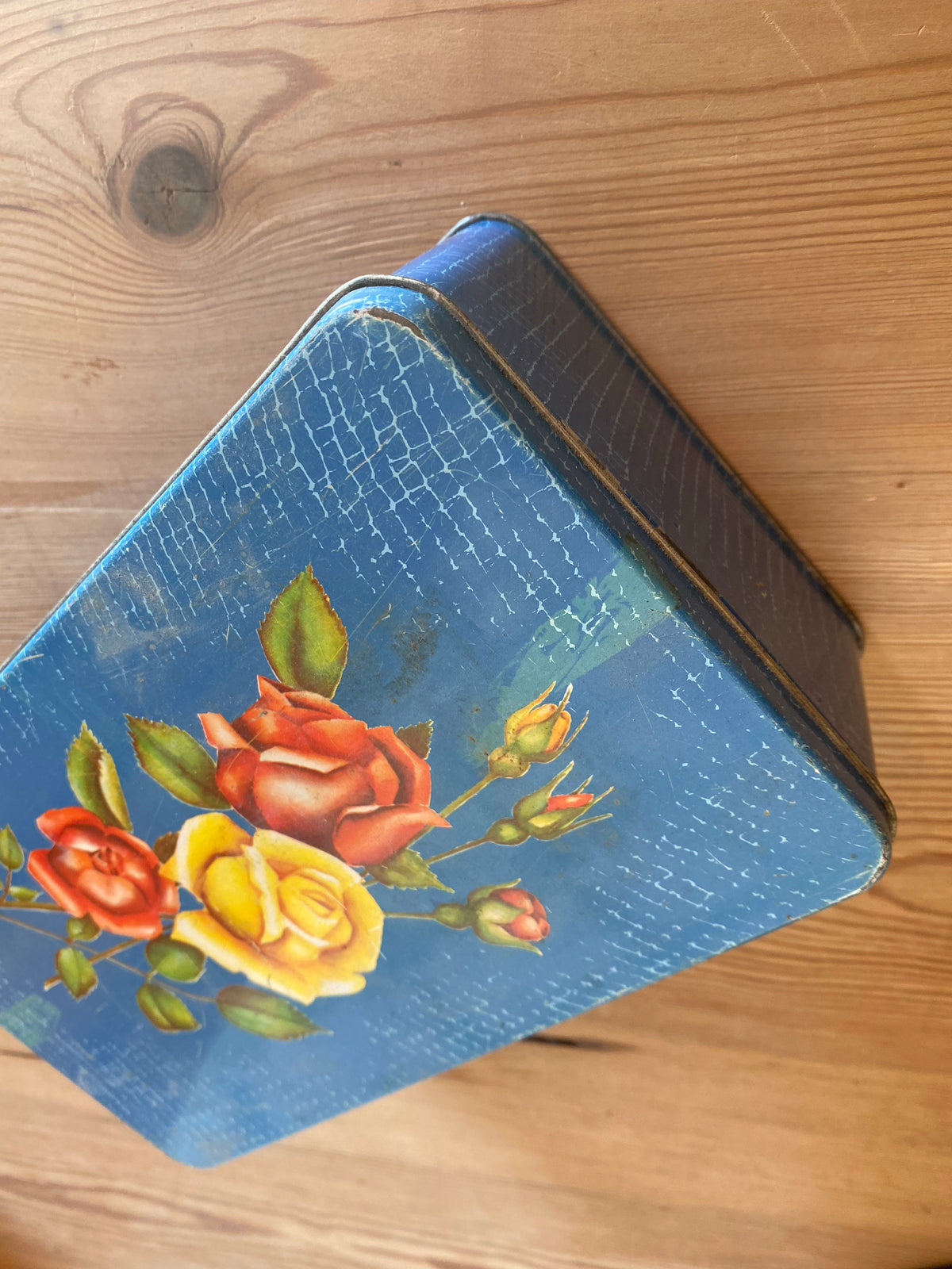 Blå plåtburk med blommor