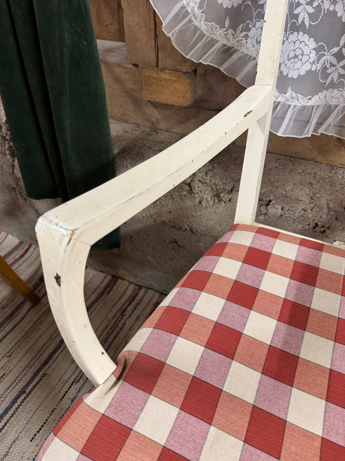 Vit karmstol med rödrutig sits