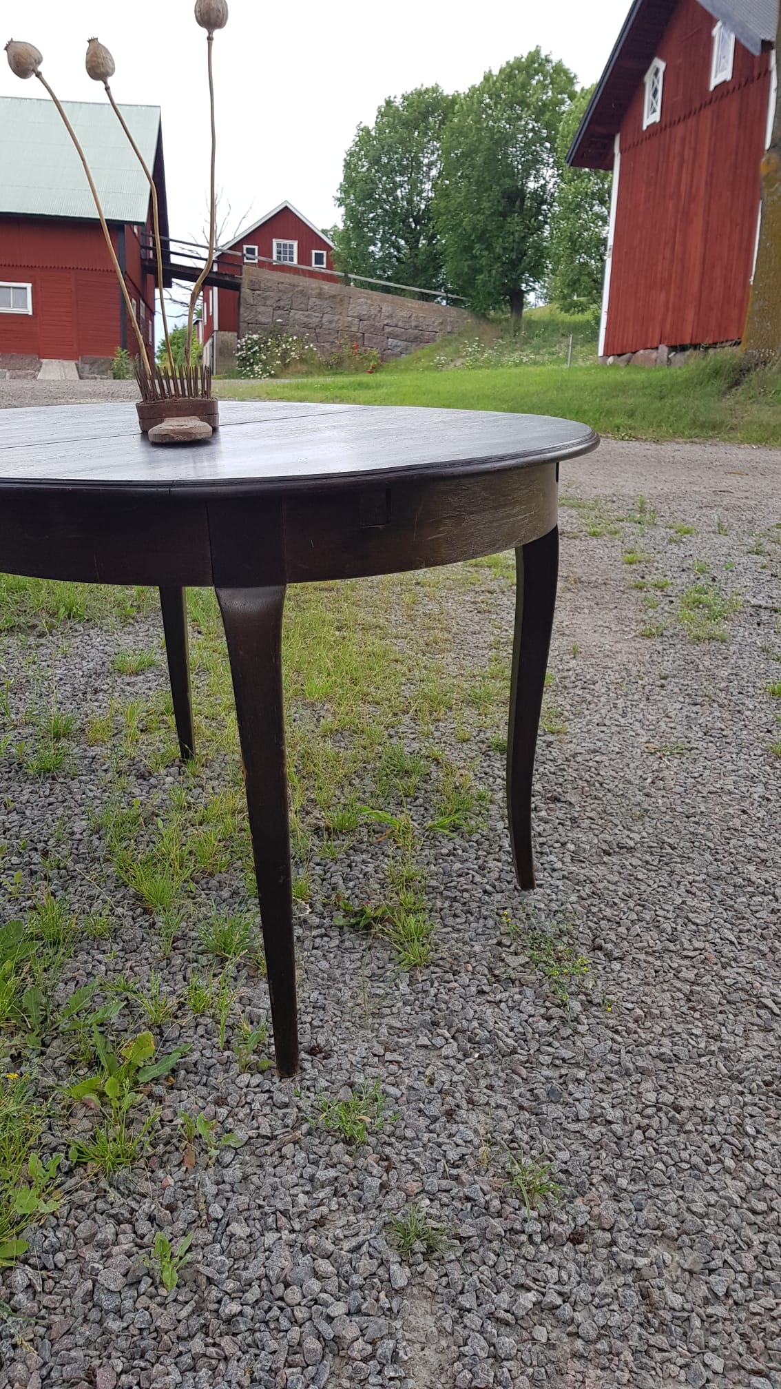 Ovalt matbord i mörkt trä med iläggsskivor