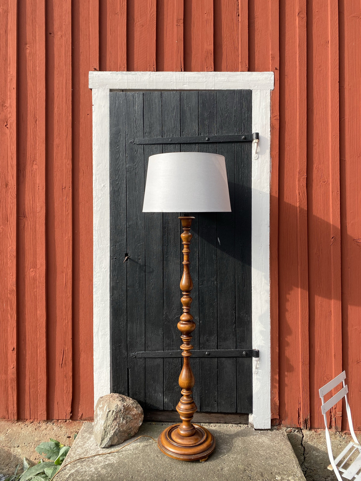 Golvlampa med svarvad fot i mörkt trä