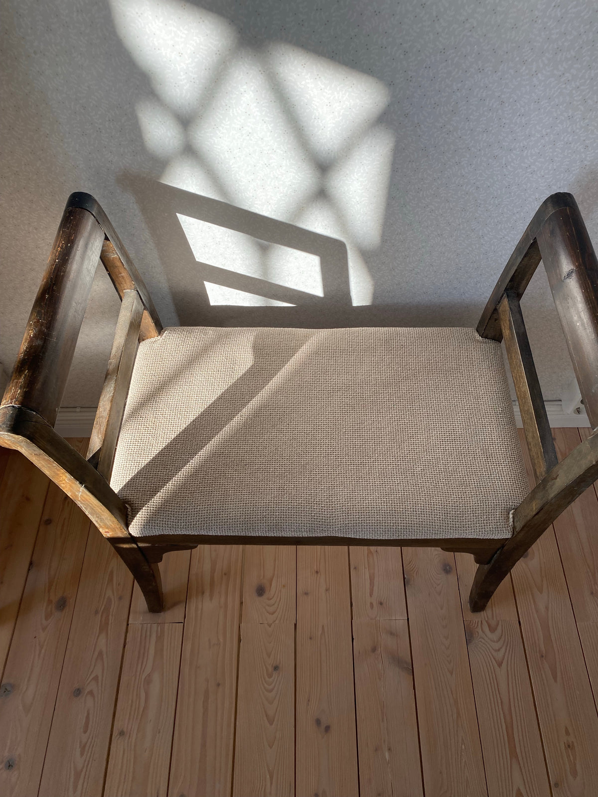 Äldre sittpall i mörkt trä