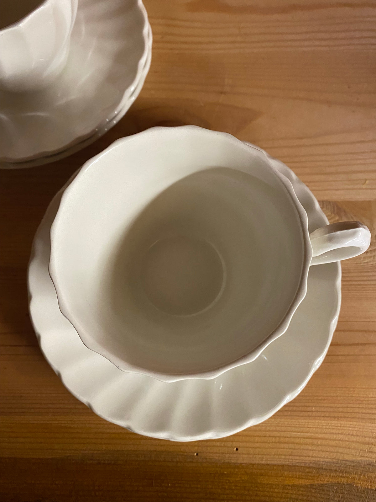 Fyra vita kaffekoppar med fat