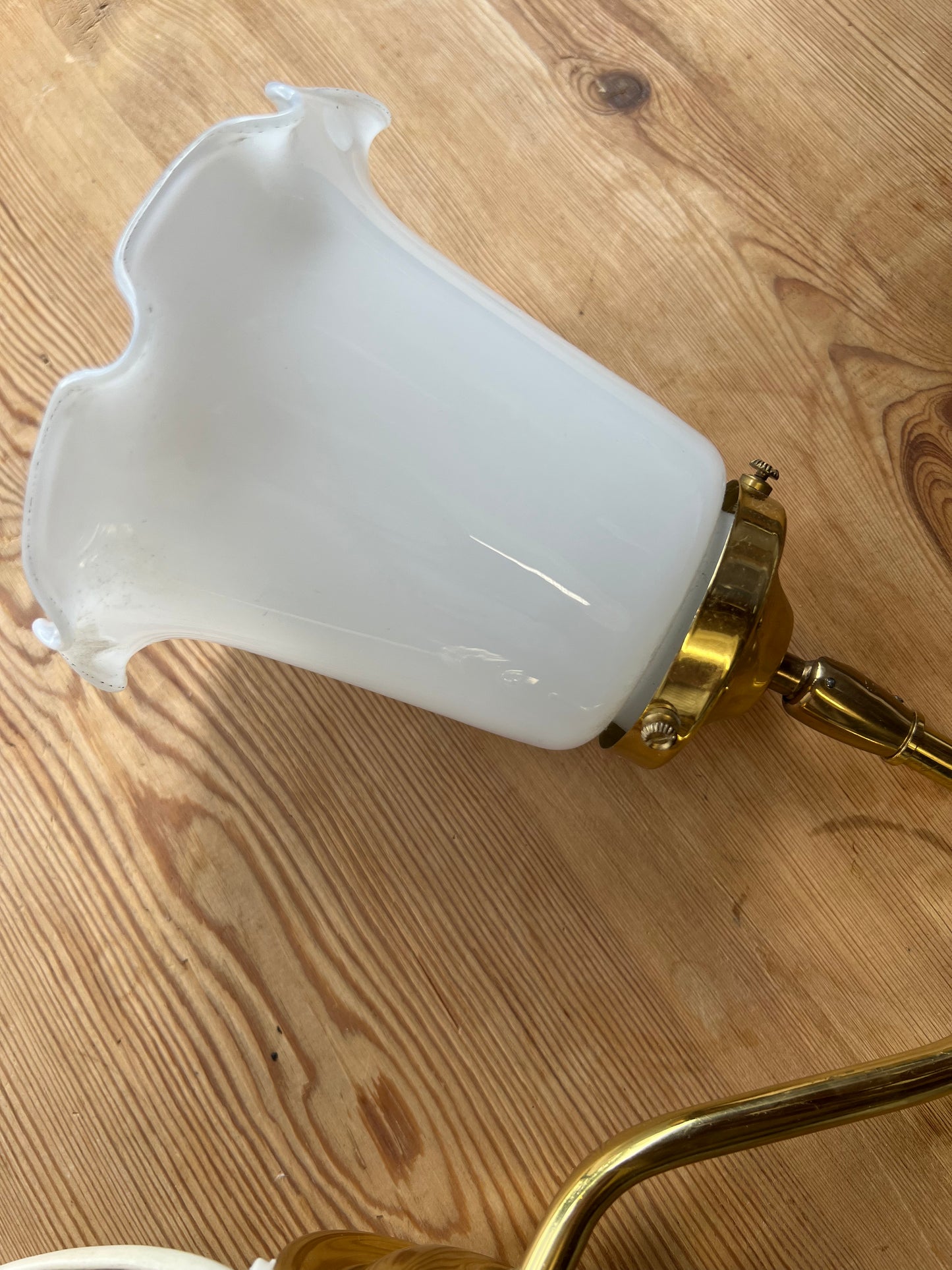 Vägglampa i porslin och mässing med vågad kant