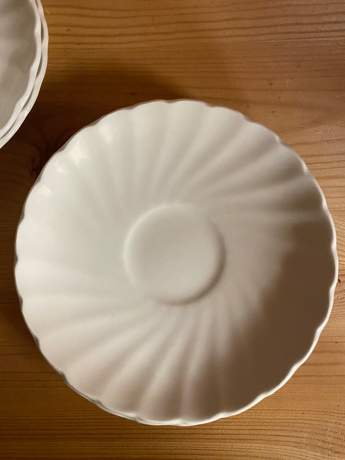 Fyra vita kaffekoppar med fat