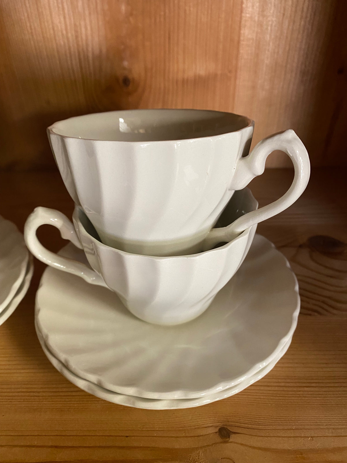 Fyra vita kaffekoppar med fat