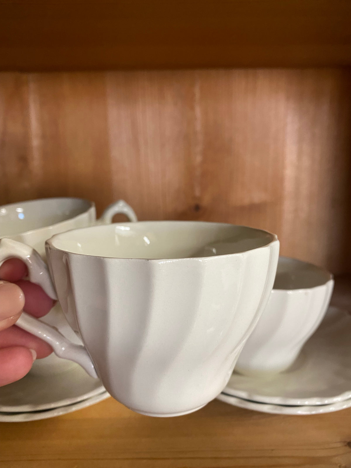 Fyra vita kaffekoppar med fat