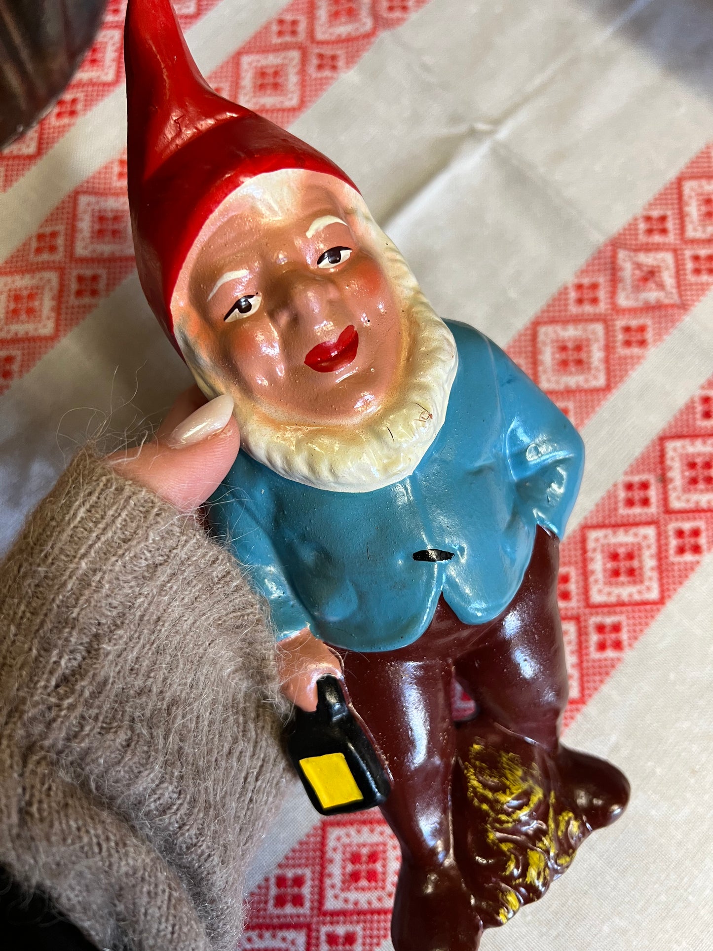 Äldre tomte med lykta i toppskick