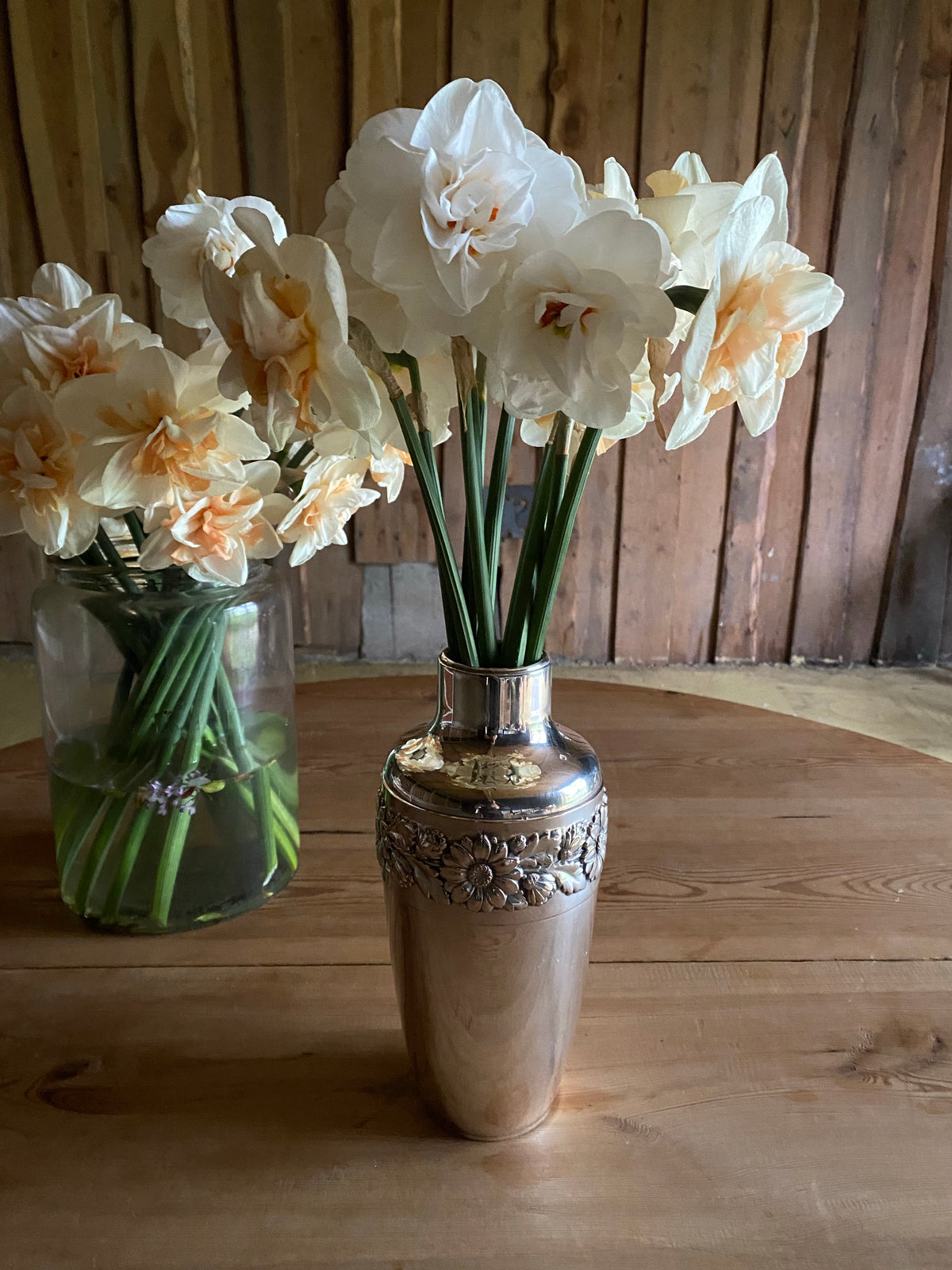 Silvervas med krans av blomstermönster runt om