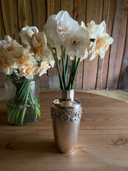 Silvervas med krans av blomstermönster runt om