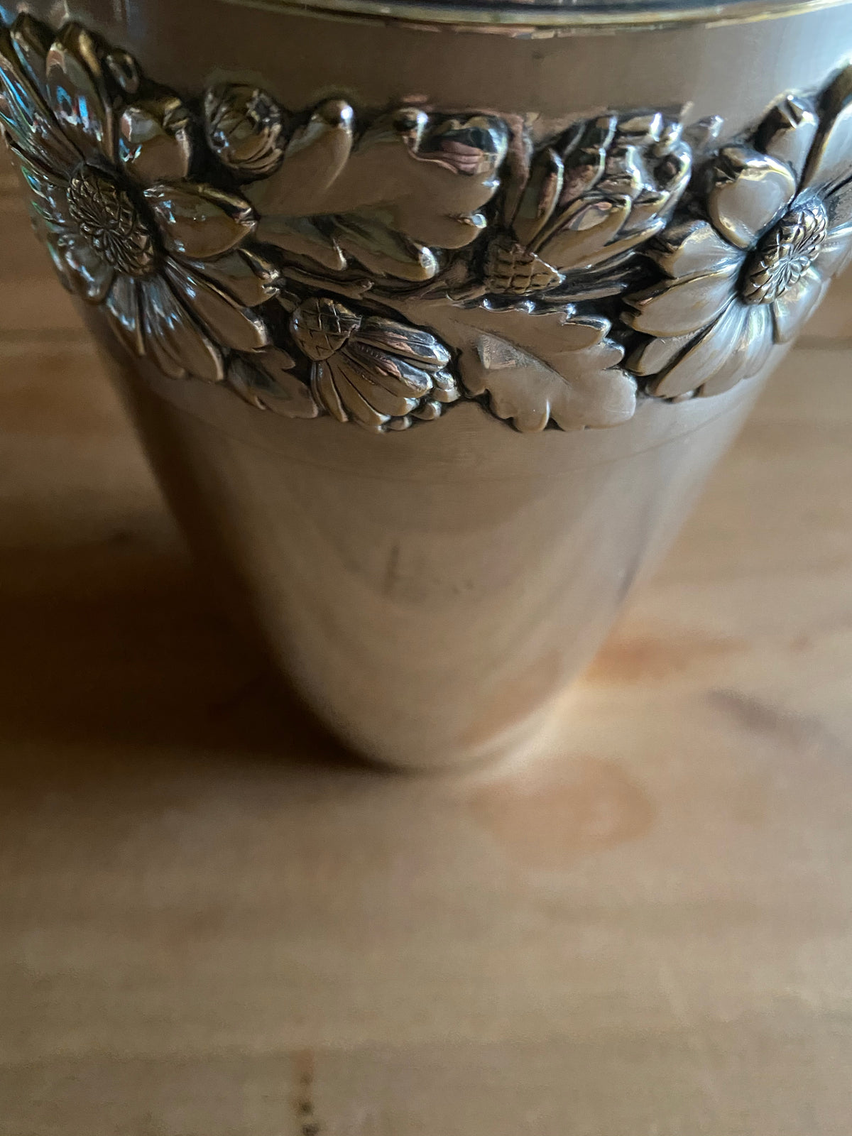 Silvervas med krans av blomstermönster runt om