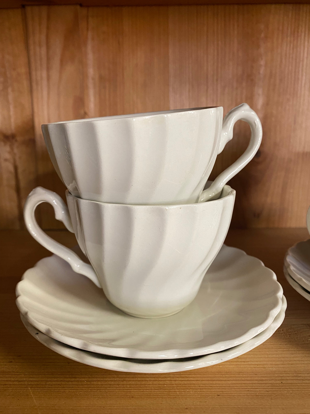 Fyra vita kaffekoppar med fat