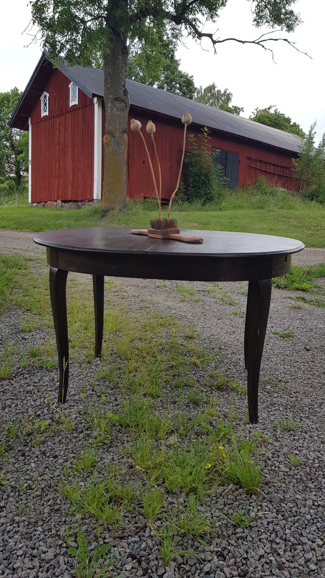 Ovalt matbord i mörkt trä med iläggsskivor