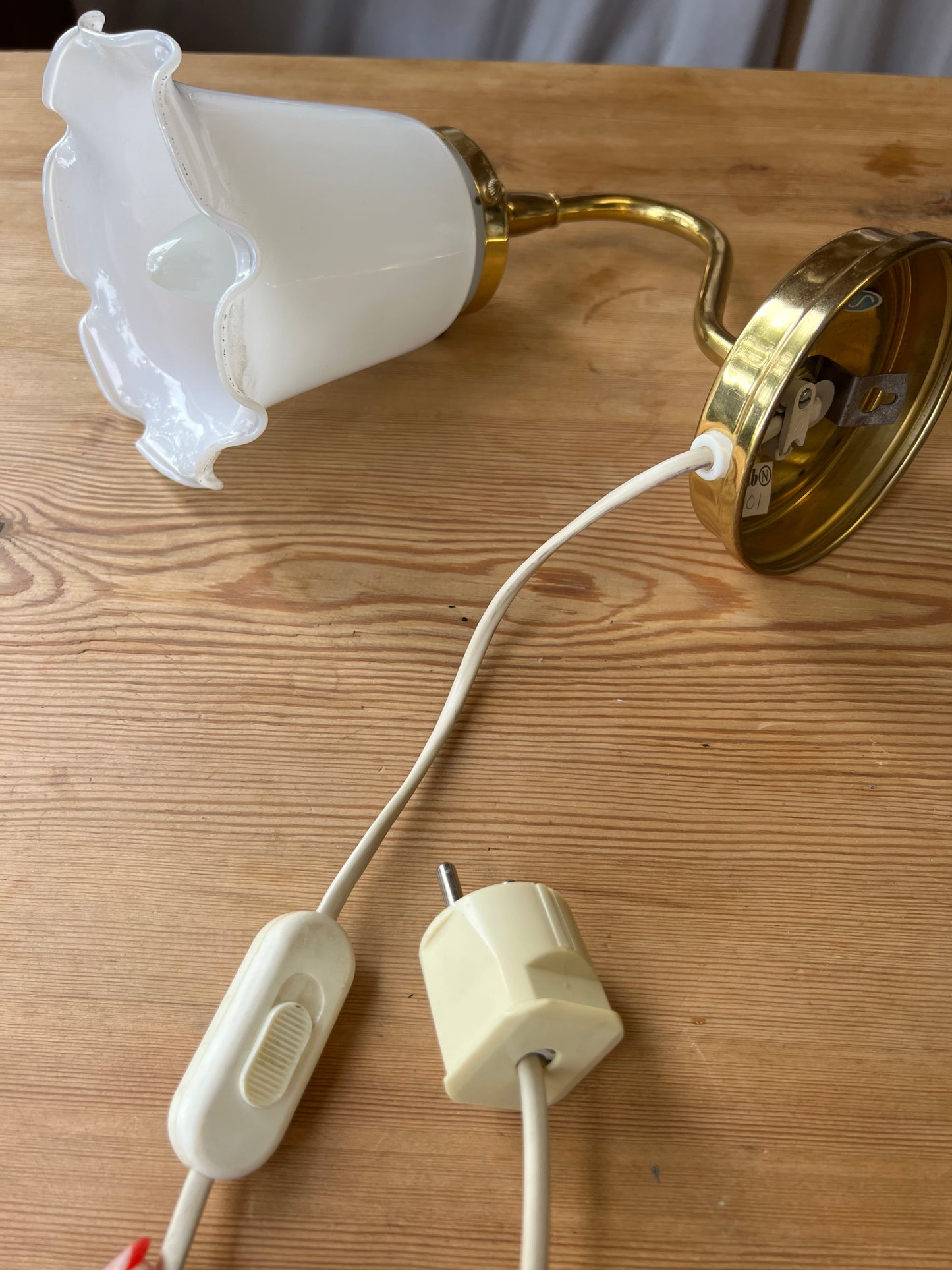 Vägglampa i porslin och mässing med vågad kant