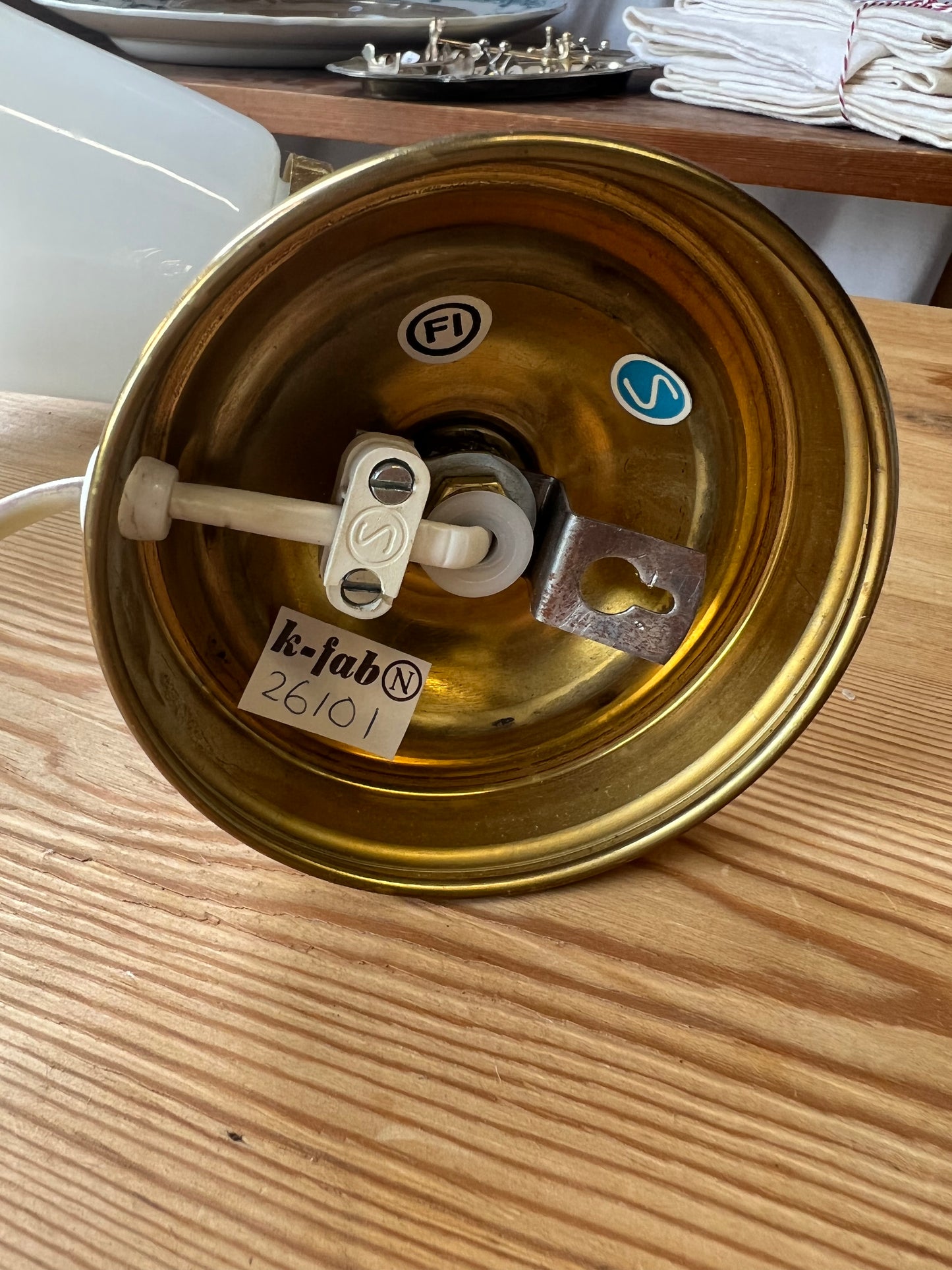 Vägglampa i porslin och mässing med vågad kant