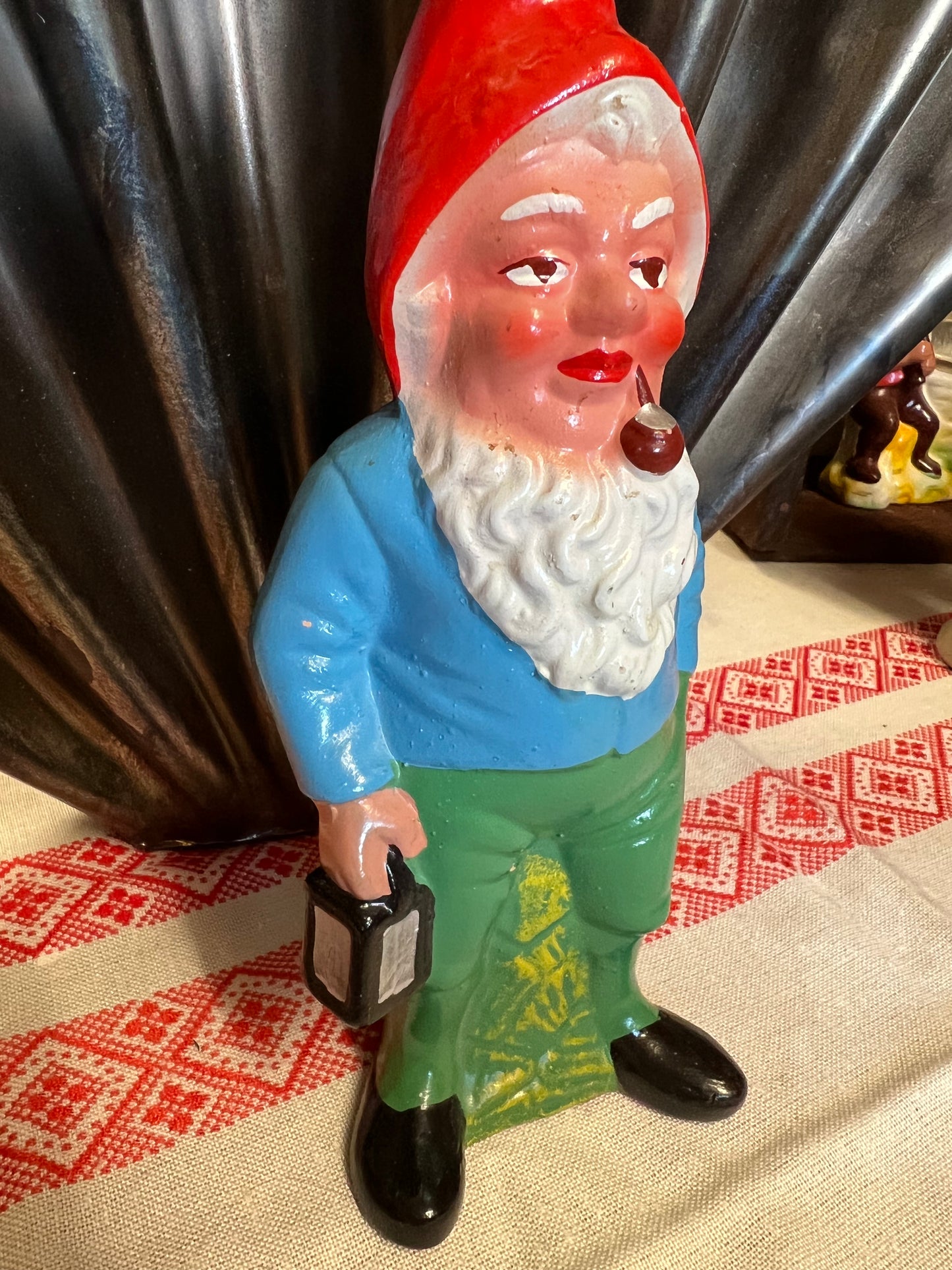 Äldre tomte med pipa och lykta i toppskick