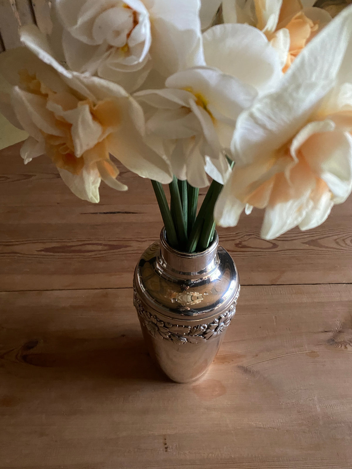 Silvervas med krans av blomstermönster runt om
