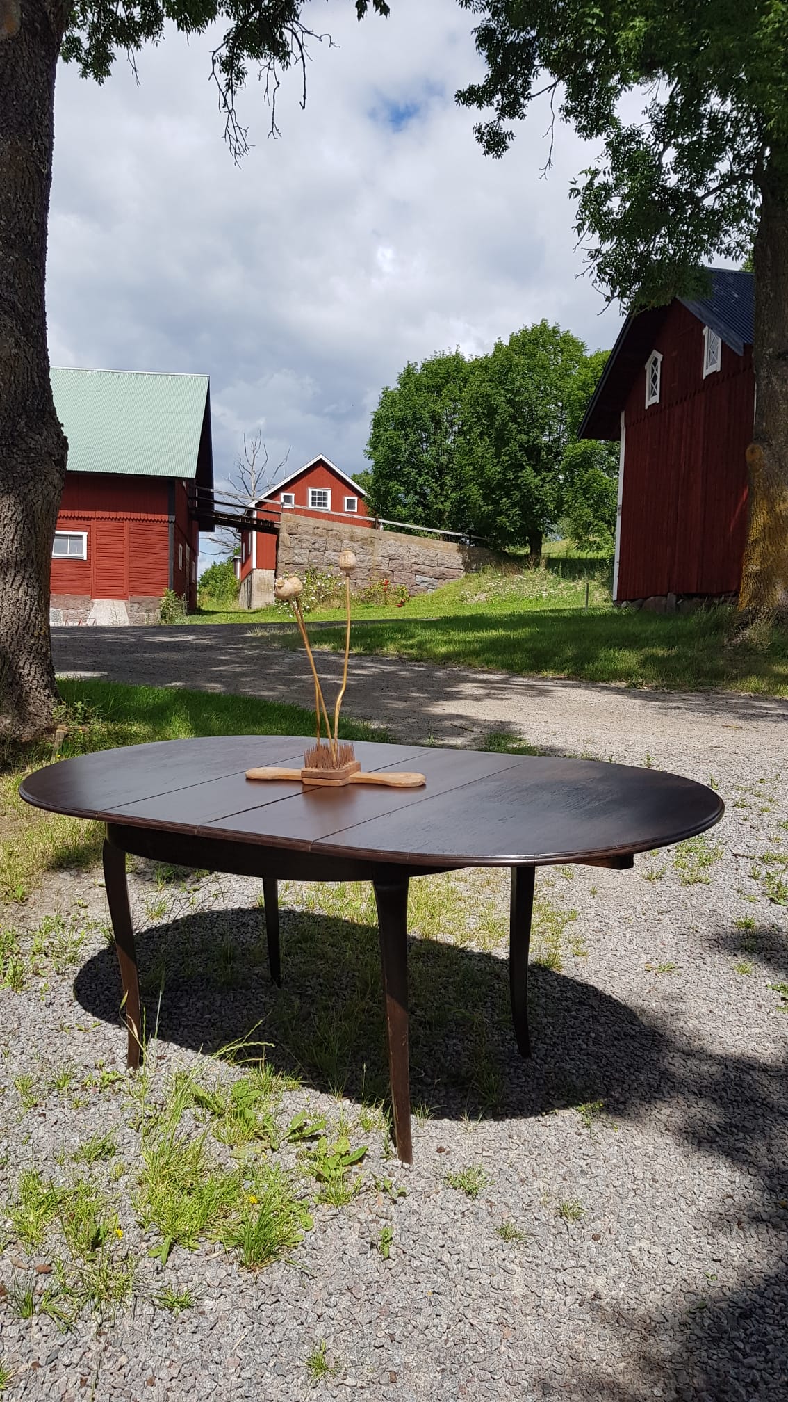 Ovalt matbord i mörkt trä med iläggsskivor