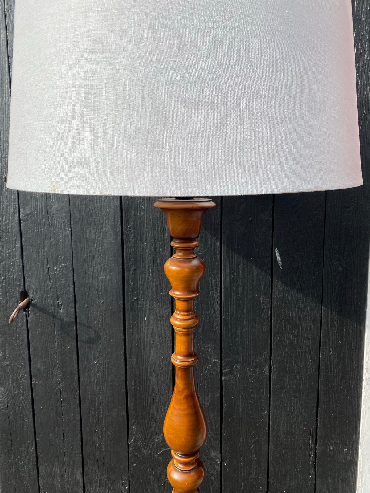 Golvlampa med svarvad fot i mörkt trä